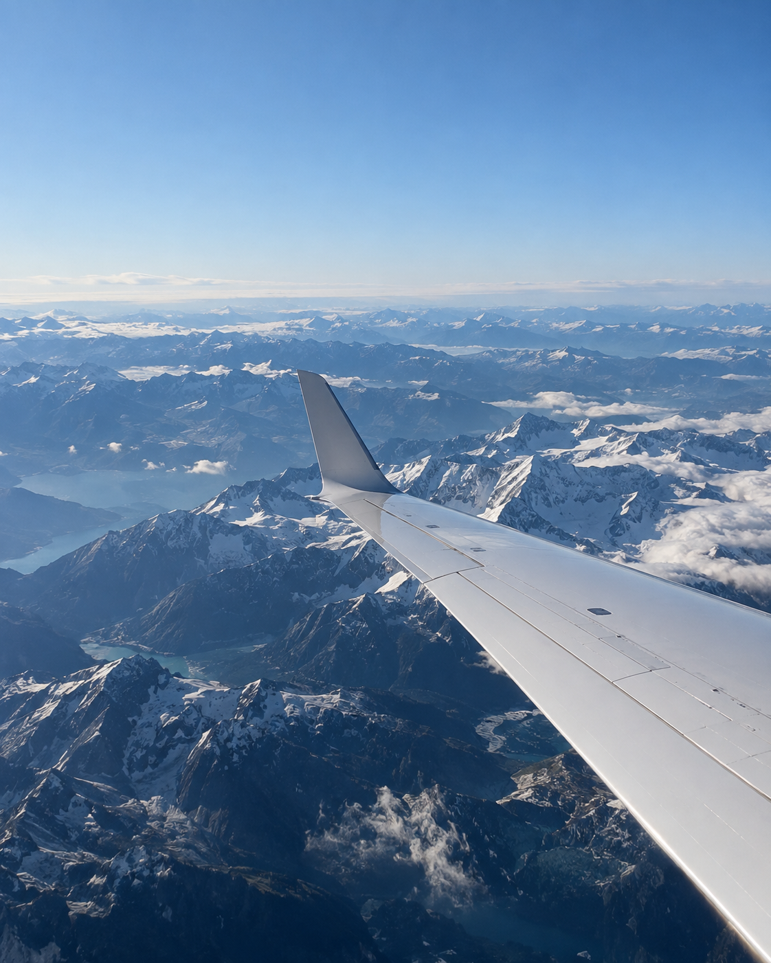 Aircraft wing over snow-covered mountains